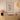 Framed 'This is our happy place' artwork on a wall above a wooden dresser with decorative items.