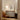 Modern interior with a brown leather chair, white cabinet, and framed 'This is our happy place' artwork on a wall.