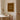 Framed artwork with more espresso less depresso text on a wall above a table and chair in a room. 