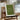 Framed print with 'This is our happy place' text on a wooden chair by a window.